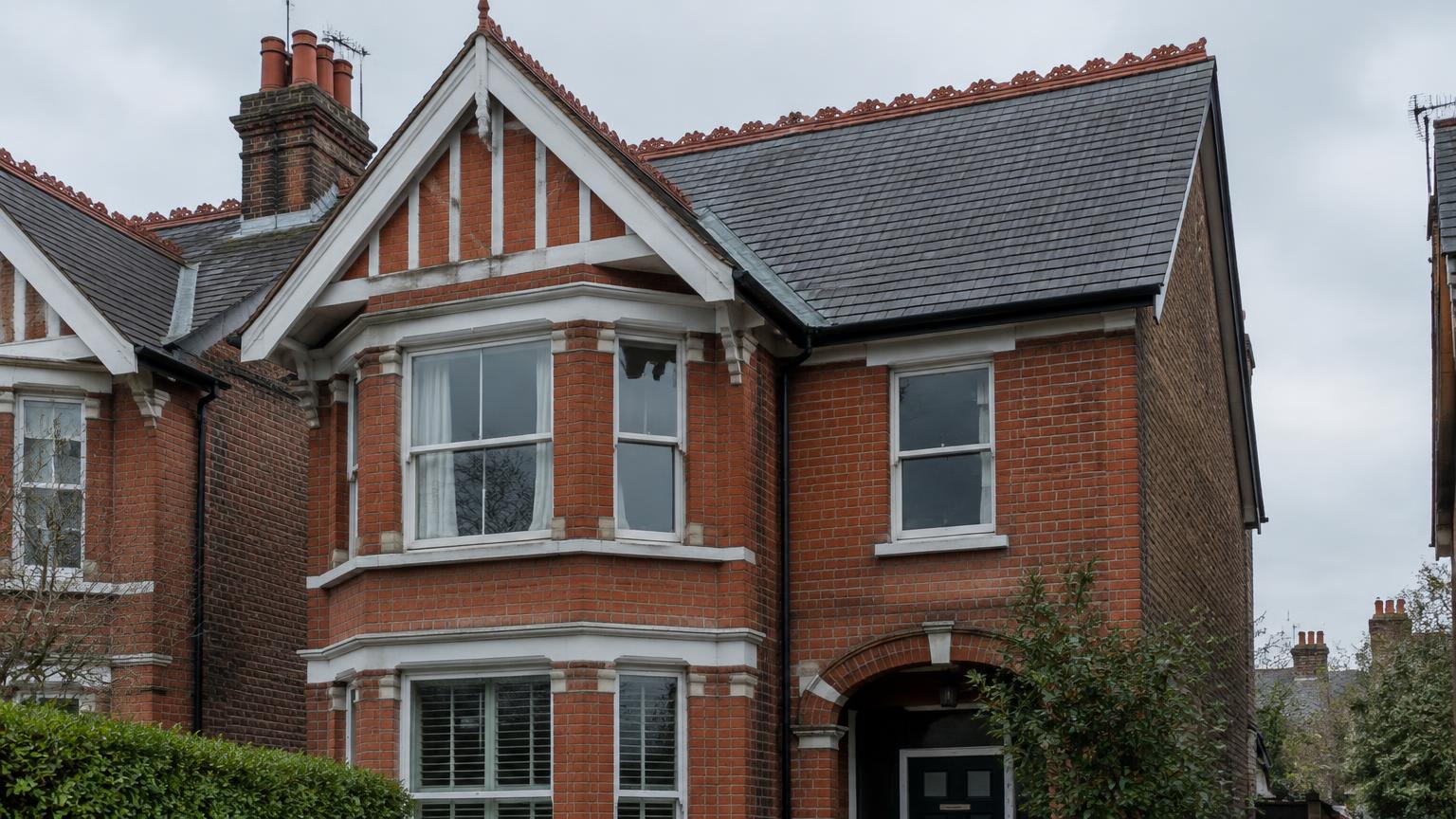 Edwardian red brick house with a steep slate roof and front gable